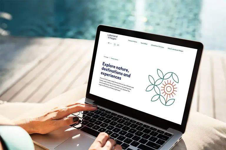 Henkilö kirjoittaa kannettavalla tietokoneella terassilla.