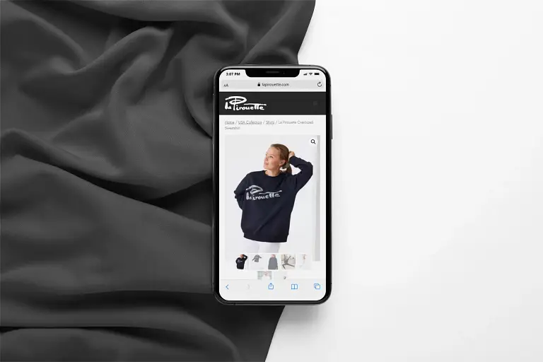 Kännykkä, jonka näytöllä on musta villapaita.