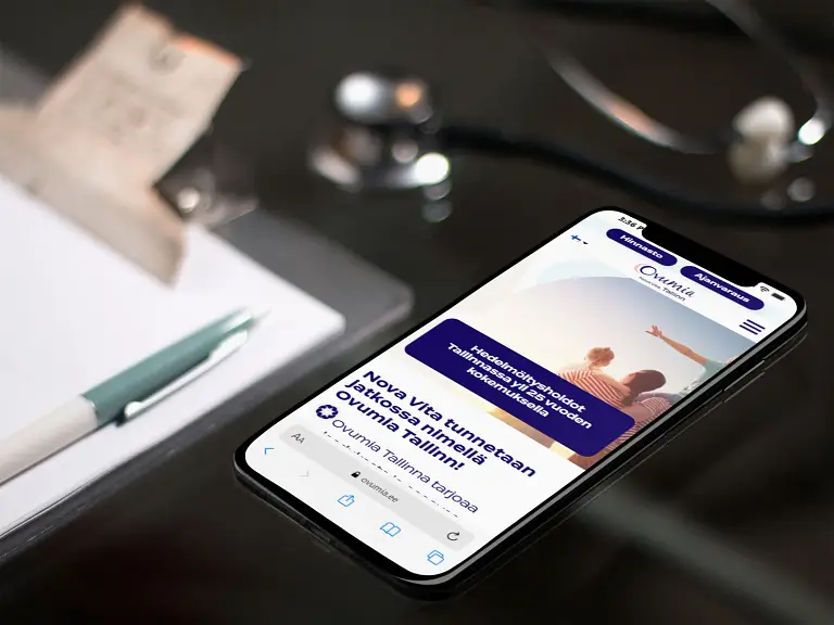 Puhelin, jossa on stetoskooppi, istuu pöydän päällä.